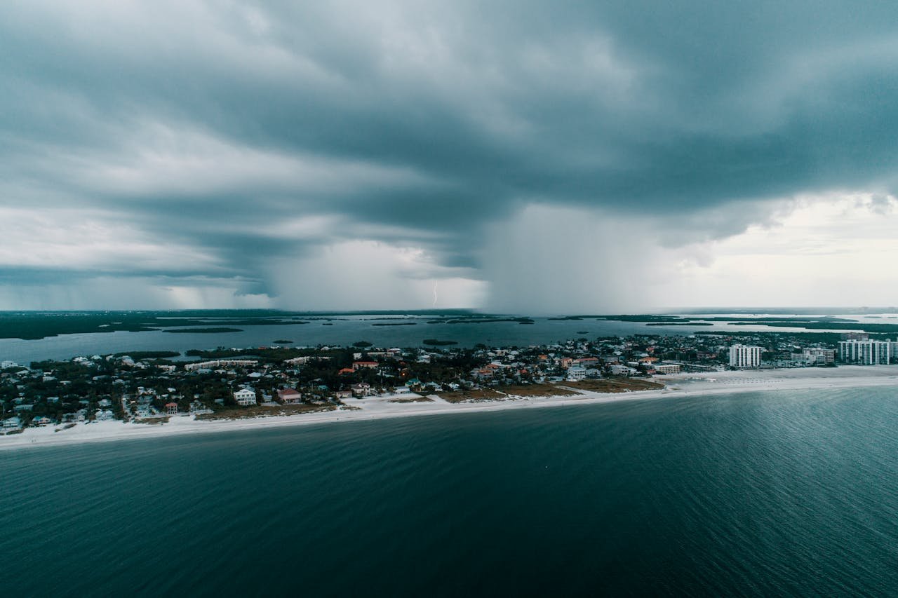 services-03 A stunning aerial view capturing a storm approaching an island village along the coast.